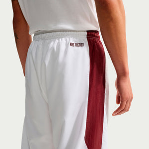 Nike Premier Repel Pants are white athletic shorts featuring a wide maroon side stripe and NIKE PREMIER text near the waistband, ideal for an official soccer gear game-day look.