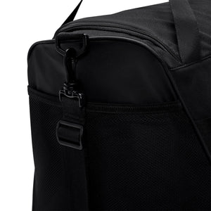Close-up of a black Nike Academy Duffel Bag, showing the zippered main compartment and the plastic clip attachment for a shoulder strap.