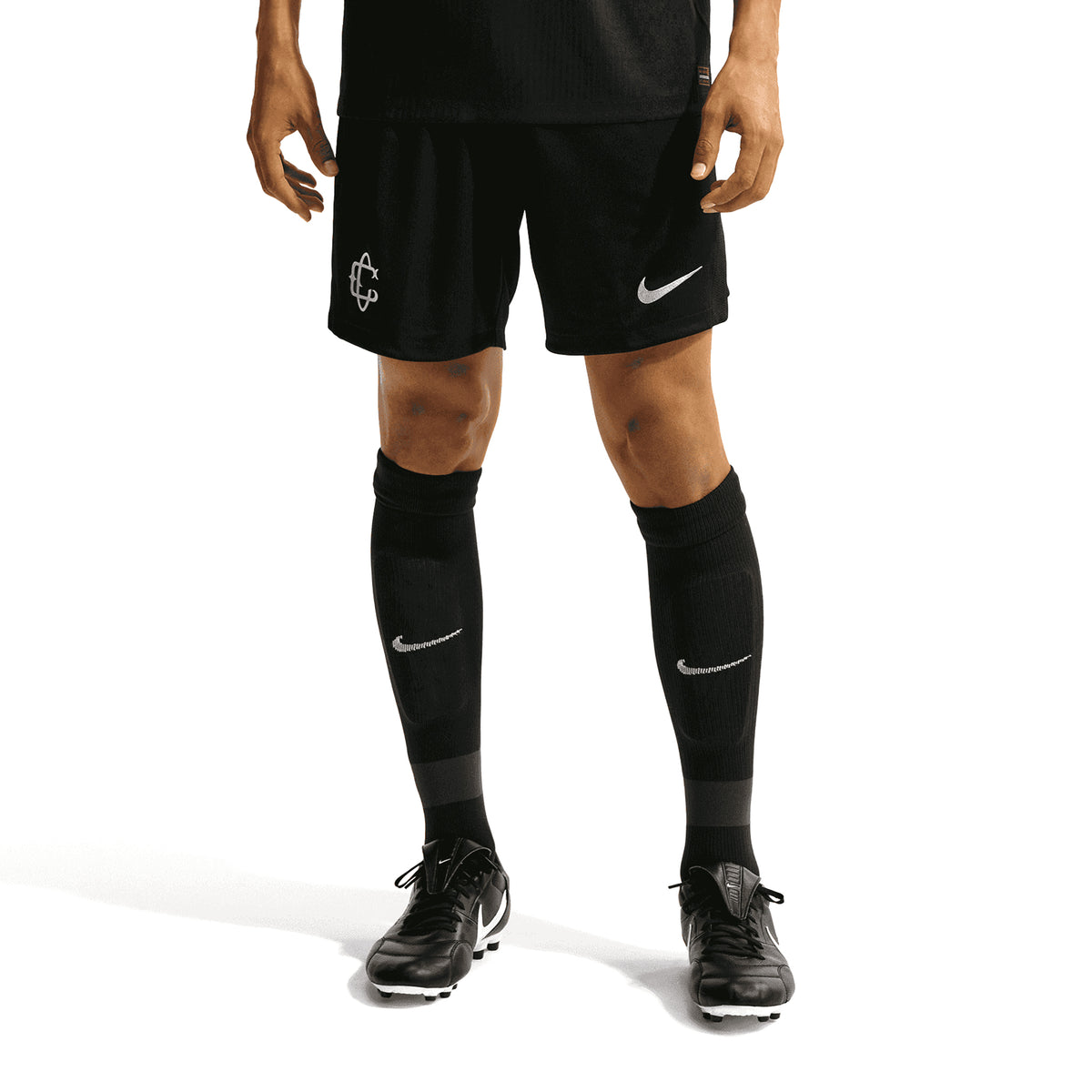 A person wearing Nike Chivas 26/27 Stadium Third Shorts, black soccer socks, and black cleats as part of their game-day look.