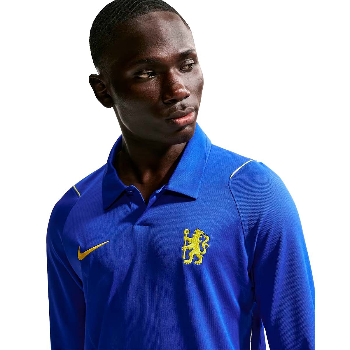 A person wearing a blue Nike Chelsea FC 26/27 Long Sleeve Stadium Home Jersey featuring a yellow lion emblem on the chest and a Nike Dri-FIT ADV swoosh logo.
