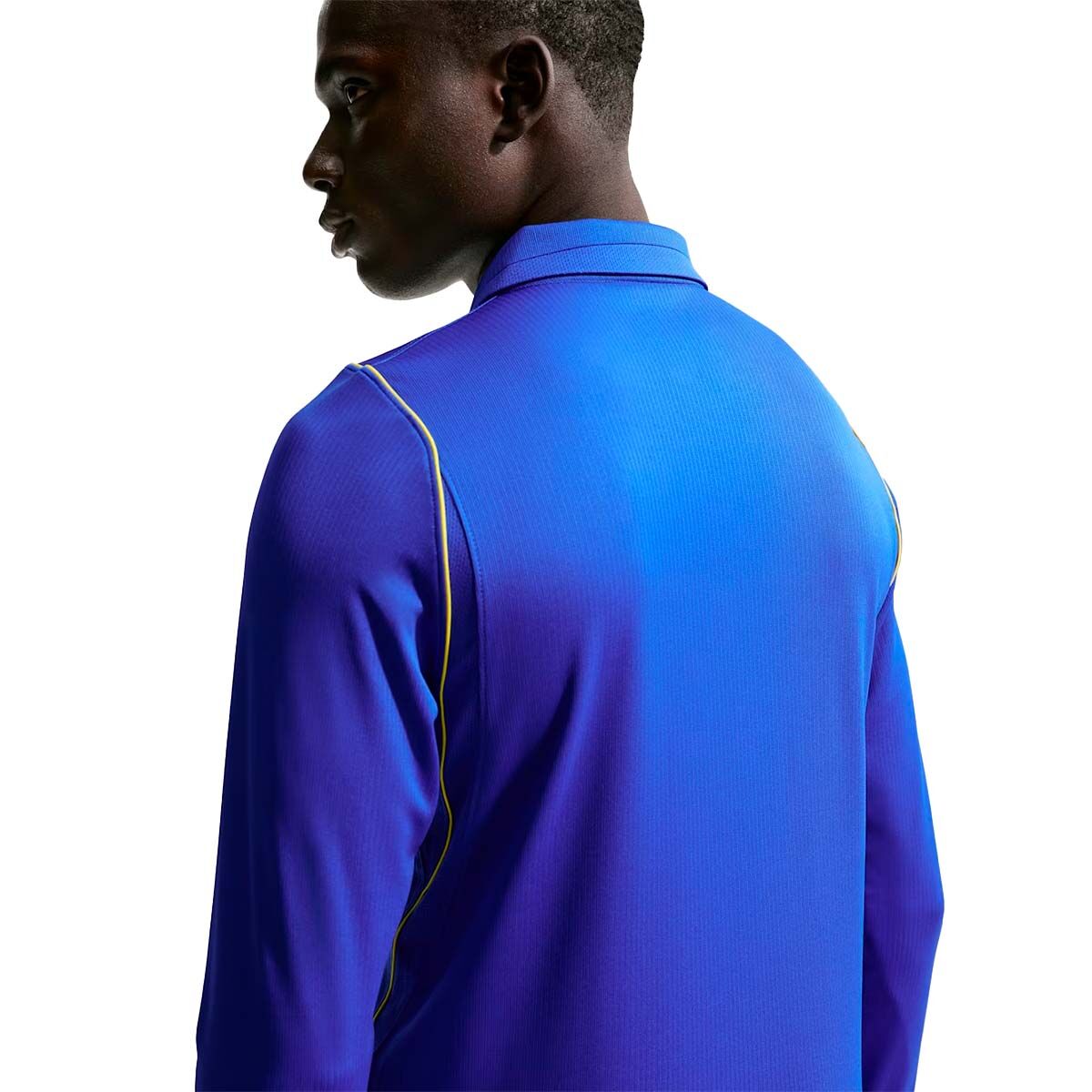 A person wearing a Nike Chelsea FC 26/27 Long Sleeve Stadium Home Jersey in blue with thin yellow piping along the shoulders.