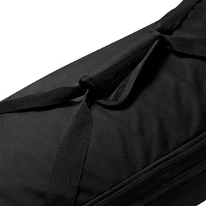 Close-up of a black Nike Academy Duffel Bag featuring a hook-and-loop fastener handle wrap on the carrying straps.