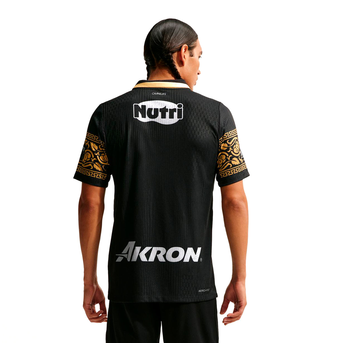 Back view of a Nike Chivas 26/27 Match Third Autenthic Jersey, featuring gold patterned sleeves, a black and white collar, and the words Nutri and Akron printed in white.