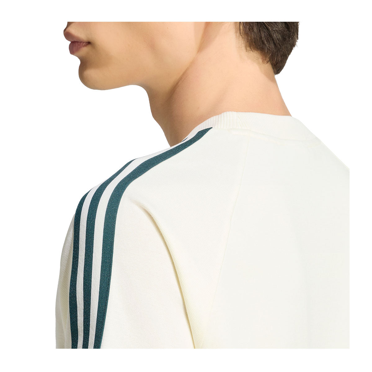 Profile view of a person in an off-white adidas Real Madrid Originals T-Shirt featuring three dark green stripes along the shoulder.