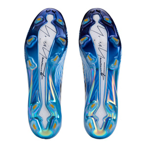 The soles of two adidas F50 Hyperfast Elite Y-3 FG Soccer Cleats, featuring a blue and white iridescent finish with a signature graphic and molded studs.